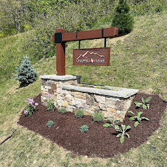 Custom Chappell Farms entrance sign on stacked stone with fresh mulch and ornamental plantings.